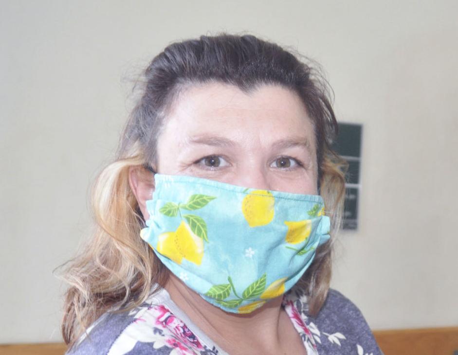 Voter wearing protective mask waits in line to vote